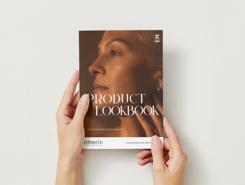 A person's hands holding a printed product lookbook titled 'Product Lookbook' against a plain light gray background. The cover features a close-up portrait of a woman in warm brown tones with the brand name 'amerin' at the bottom.